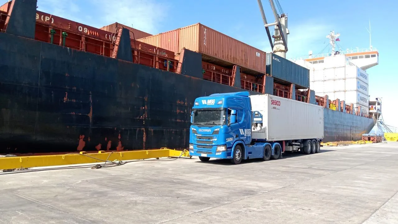 Camión de MGG junto a un buque de carga en el muelle